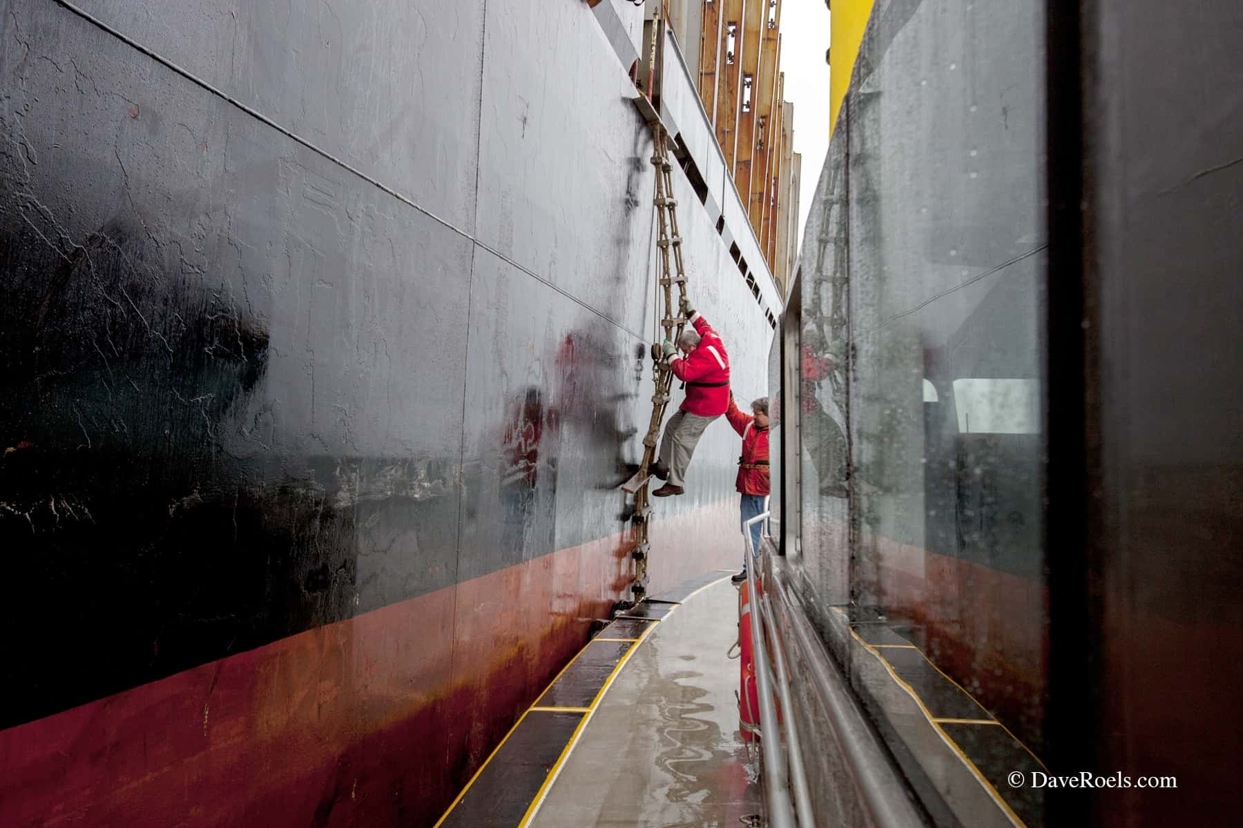 Man climbing down the side of a boat