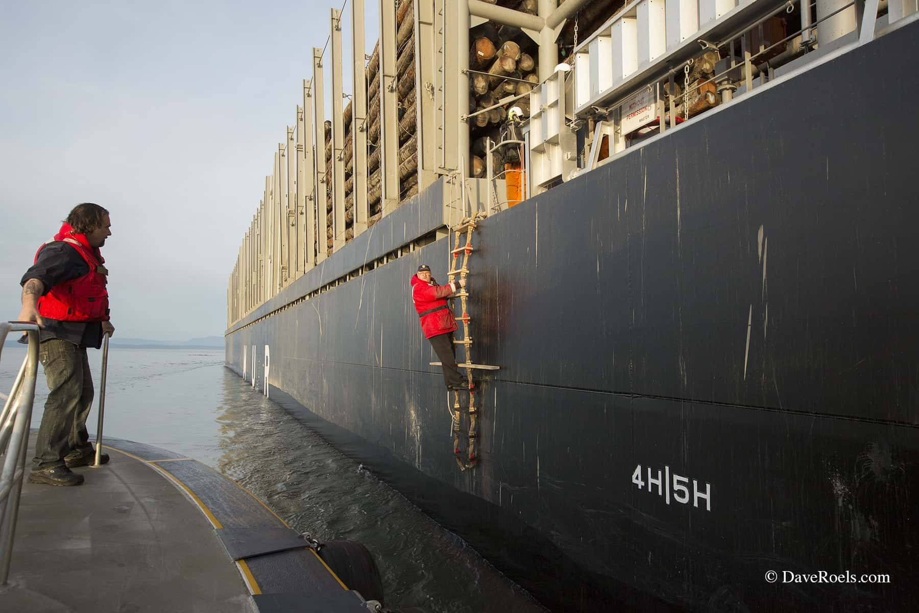 Man climbing down side of boat